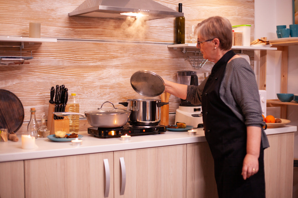 An older woman living with dementia cooking at home