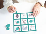 Elderly hands placing a turquoise bingo chip to their bingo card.