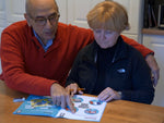 Elderly couple helping eachother do the Spark Your Mind activities.