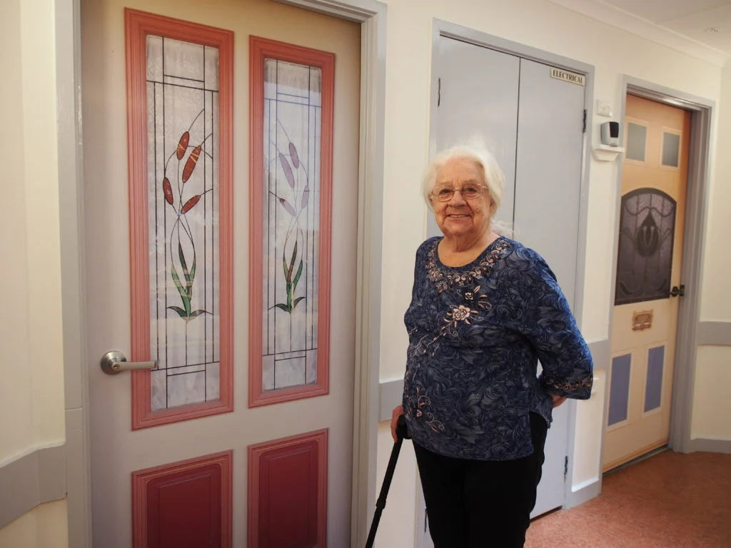 Woman standing of her door with a True Doors decal 