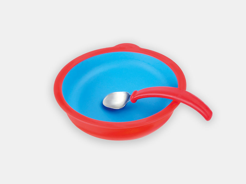 The red Ergonomically Curved Spoon from Eatwell inside a bowl from Eatwell