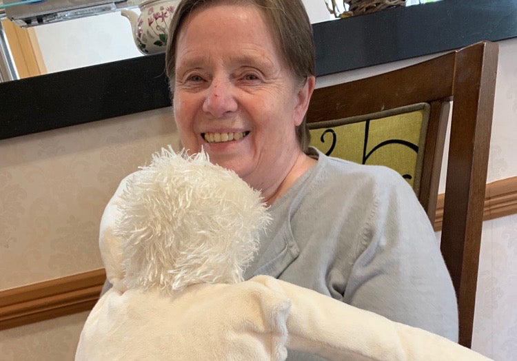 Older adult holding a HUG doll
