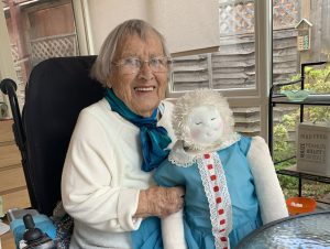 Woman holding a HUG doll in a home setting