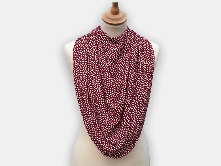 Protective pashmina bib for older adults in burgundy with white polka dots pattern.