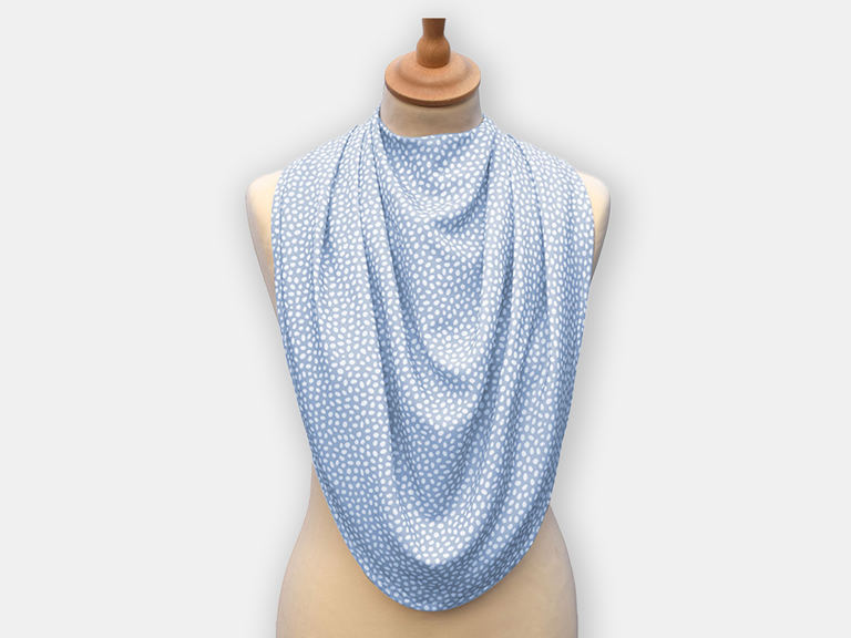 The dignifying protective pashmina bib for older adults in the light blue with white polka dots pattern.