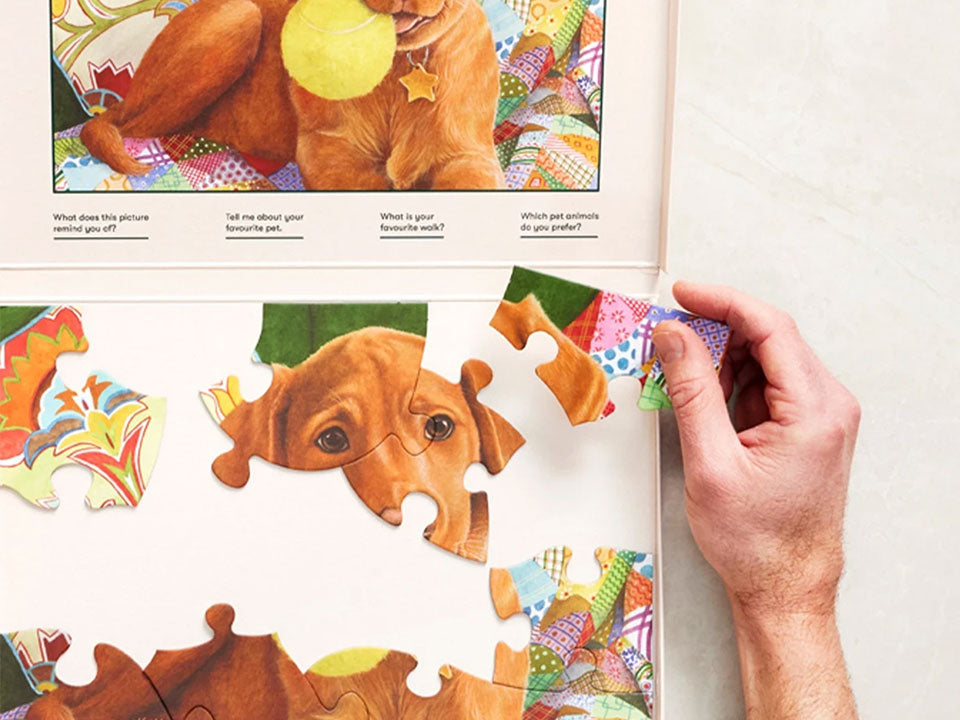 Close-up of a hand adding a piece to an adapted 13-piece Relish puzzle for people living with dementia.