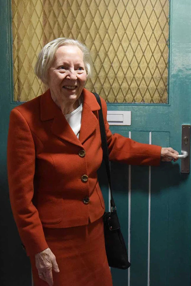 Woman in a red outfit in front of a True Doors decal