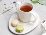 White Saucer with tea and macaroons 