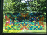 Colored peal and stick transom on a window giving a stained glass effect with the sunlight.