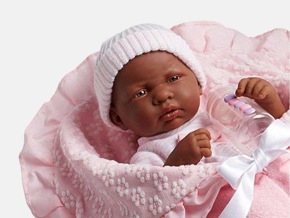 Close-up of the African-American doll ''La Newborn'' wrapped in a pink blanket with her baby bottle.