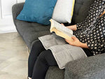 Someone reading a book with a Fiora Weighed lap pad