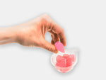 A hand taking a raspberry hydrating water and electrolyte jelly drop from a snack pot.