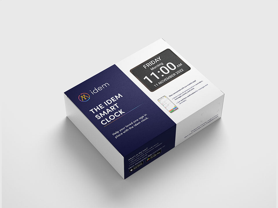 The Idem Smart Calendar Clock packaging showing the clock and a phone with the caregiver app features.