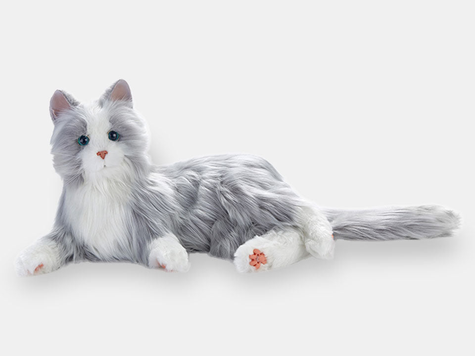 The silver interactive cat from Joy for All, for people living with dementia, laying on its side.