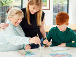 Older woman with her grandson and her caregiver, painting the water activated Relish Aquapaint set.