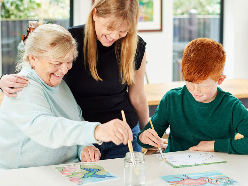 Older woman with her grandson and her caregiver, painting the water activated Relish Aquapaint set.