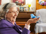 An older lady holding and interacting with the blue walker squawker bird companion.